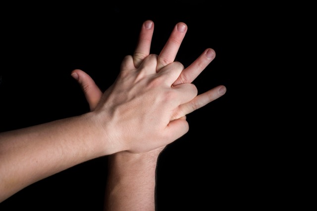 hands positioned for CPR compressions on a black background