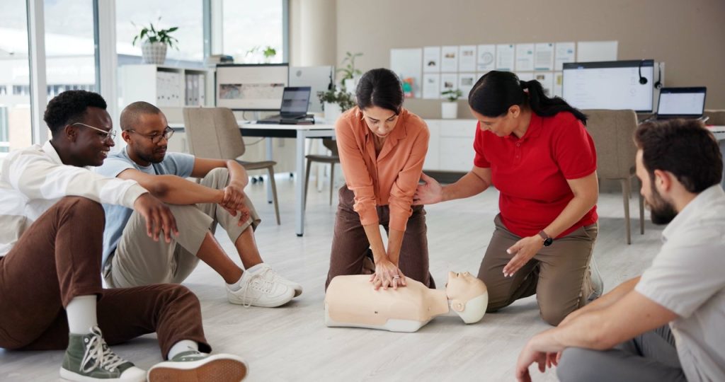 CPR and first aid training with a group in a workplace office